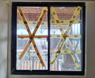 台北南京東路住宅玻璃除膠前＿防颱膠帶層層堆疊難以清除